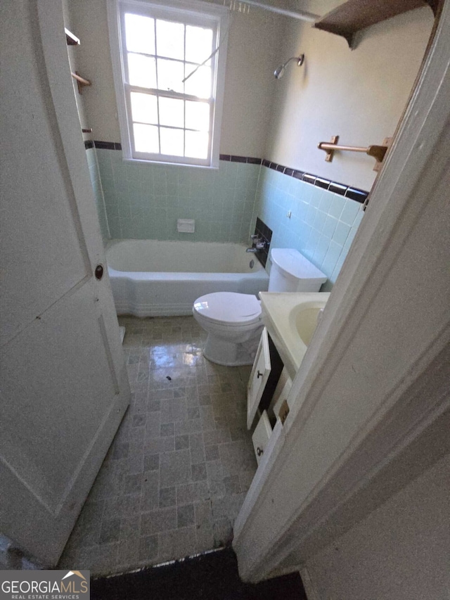 bathroom featuring tile patterned flooring, vanity, tile walls, and toilet