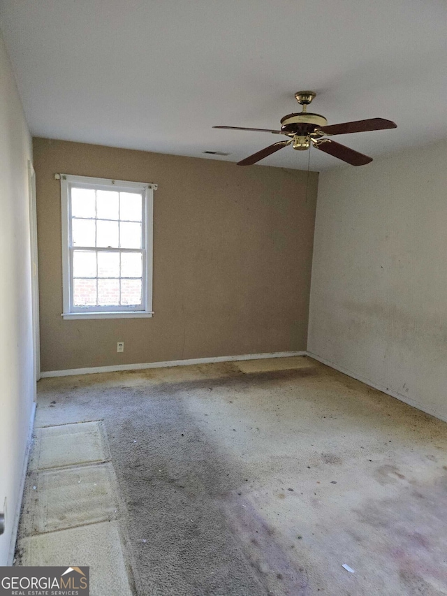 carpeted spare room featuring ceiling fan