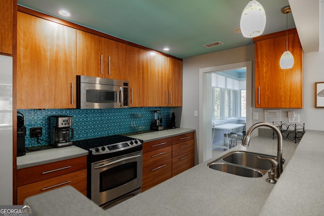 kitchen featuring pendant lighting, sink, appliances with stainless steel finishes, and tasteful backsplash