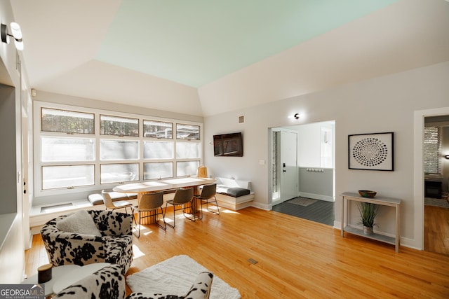 living room with hardwood / wood-style floors and vaulted ceiling