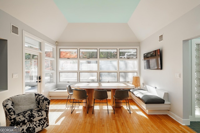 sunroom / solarium featuring a healthy amount of sunlight and vaulted ceiling