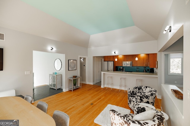 living room with lofted ceiling and light hardwood / wood-style flooring