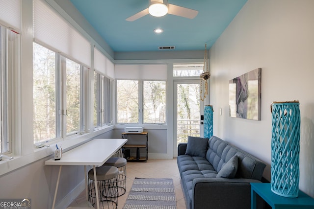 sunroom / solarium featuring plenty of natural light and ceiling fan