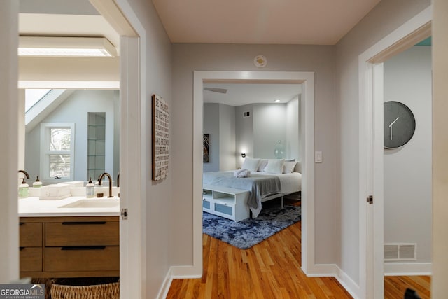 hallway featuring light wood-type flooring and sink