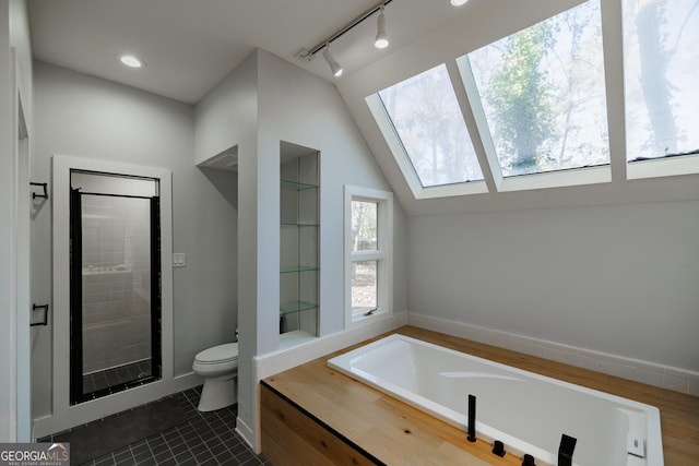 bathroom featuring toilet, tile patterned floors, separate shower and tub, and lofted ceiling with skylight