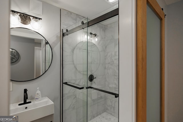 bathroom featuring an enclosed shower and sink