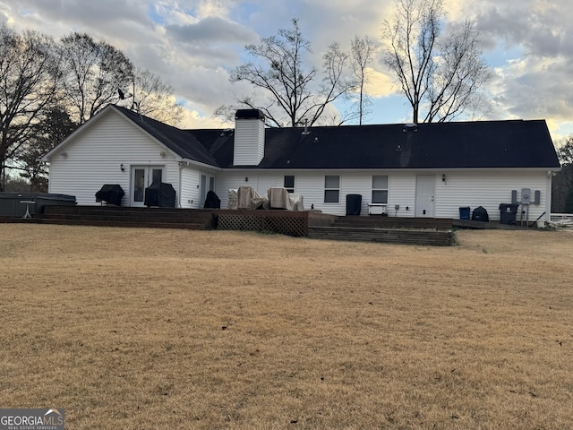 rear view of property with a lawn, french doors, and a deck