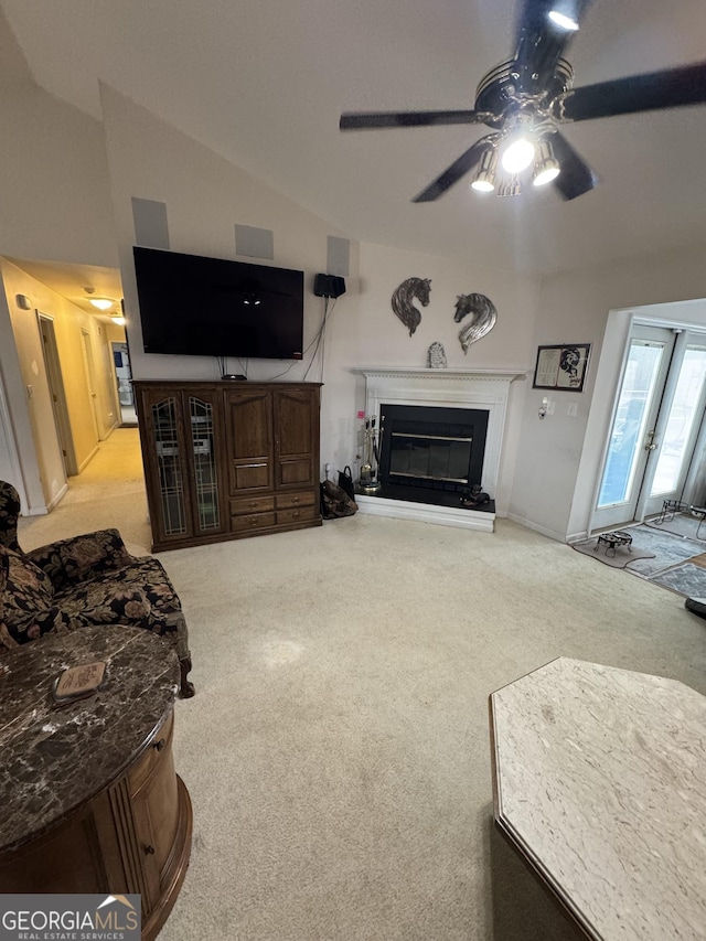 carpeted living room featuring ceiling fan and vaulted ceiling