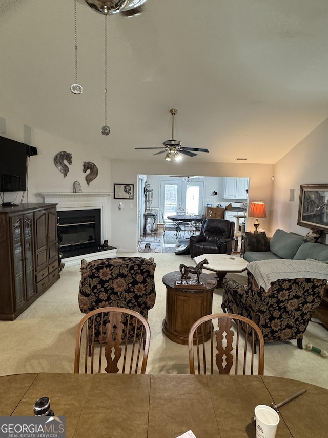 dining space with light colored carpet, ceiling fan, and lofted ceiling