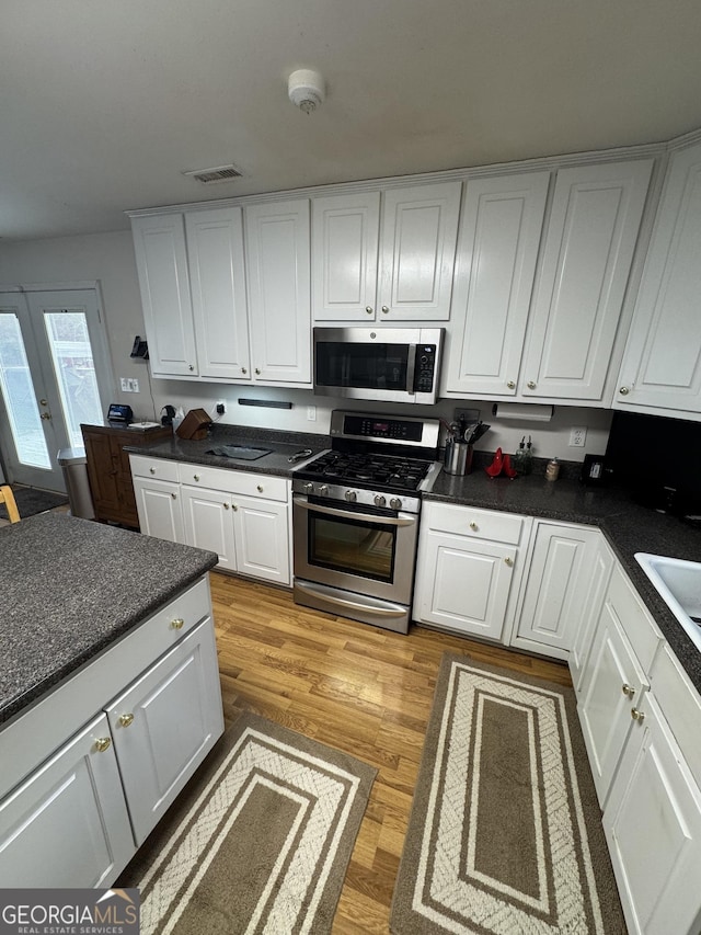 kitchen featuring white cabinetry, french doors, stainless steel appliances, and light hardwood / wood-style floors