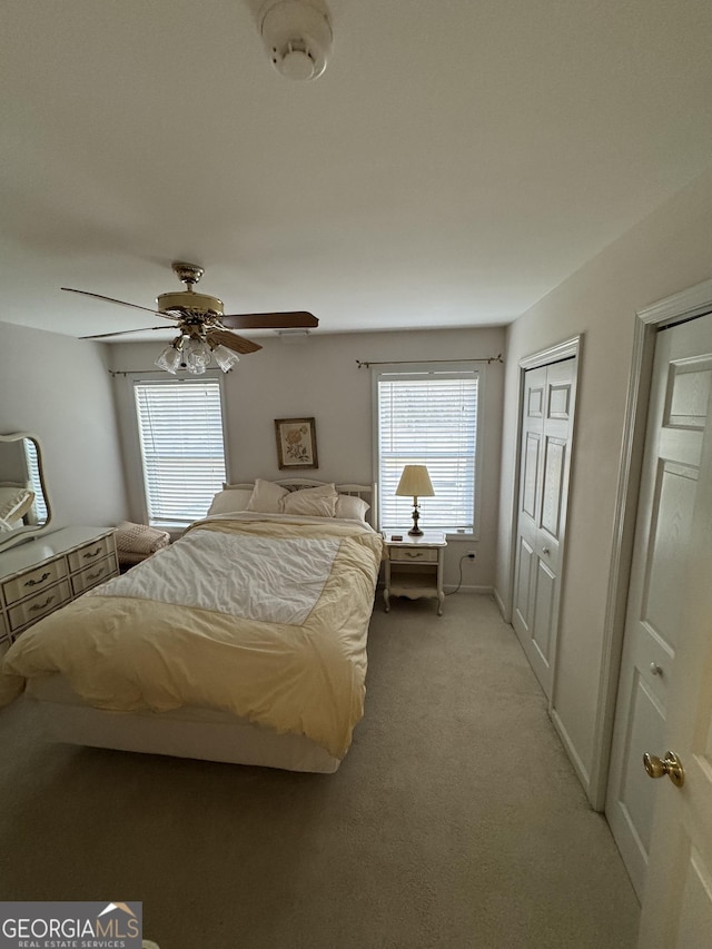 carpeted bedroom with multiple windows and ceiling fan