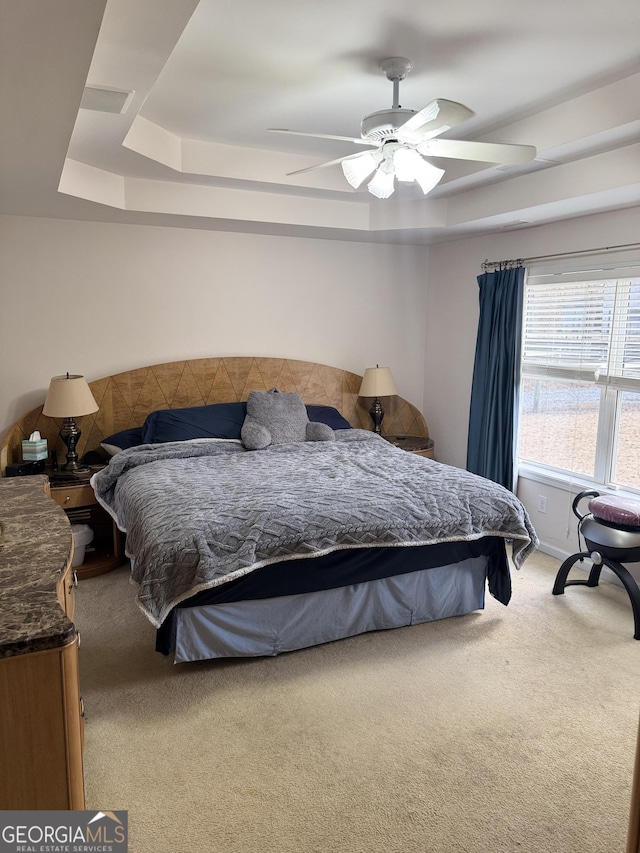 bedroom featuring a tray ceiling, ceiling fan, and carpet