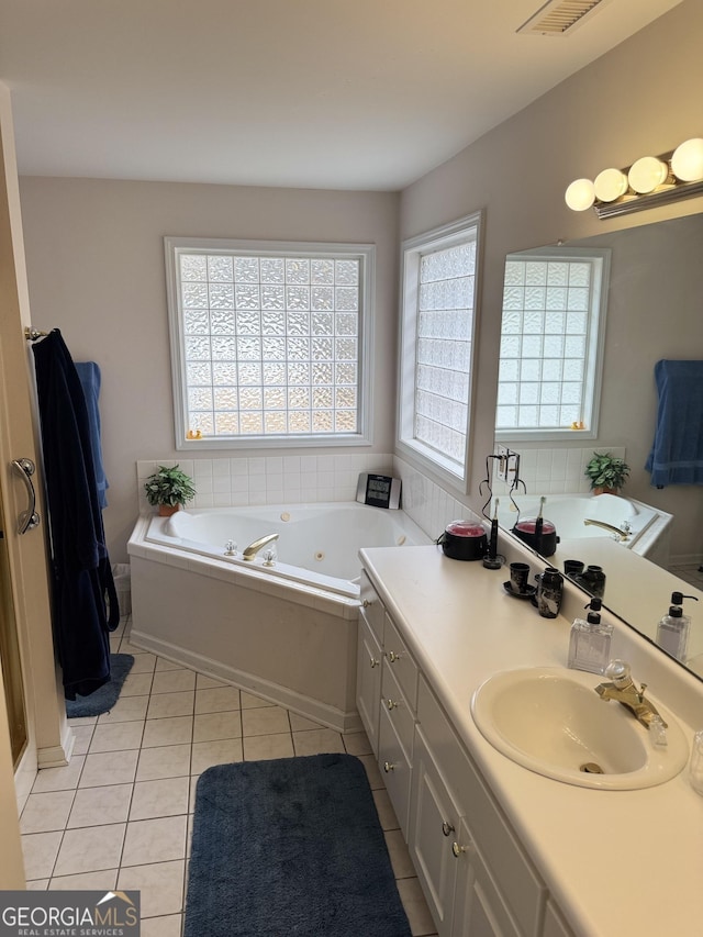 bathroom with tile patterned floors, vanity, and a tub