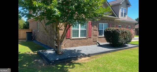 view of side of home with a lawn and cooling unit