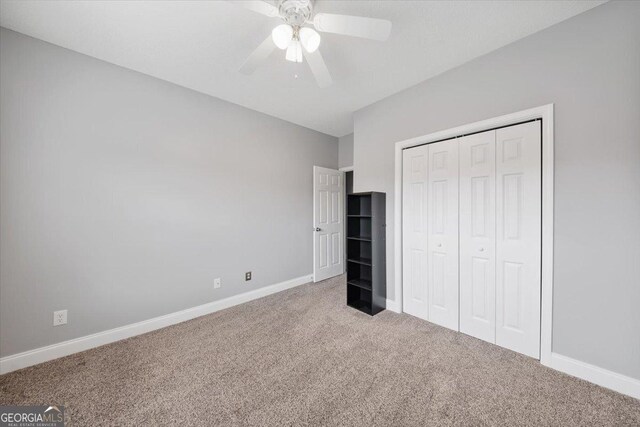 unfurnished bedroom with ceiling fan, a closet, and carpet floors