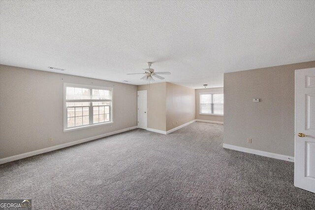 unfurnished room with ceiling fan, carpet, and a textured ceiling