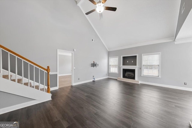 unfurnished living room featuring ceiling fan, dark hardwood / wood-style floors, ornamental molding, and high vaulted ceiling