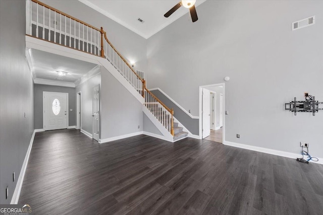 foyer with a high ceiling, dark hardwood / wood-style floors, ceiling fan, and crown molding