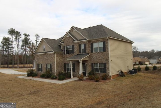 view of front of property featuring central air condition unit and a front yard