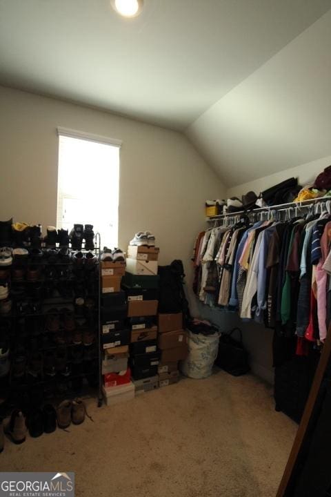 walk in closet featuring carpet flooring and vaulted ceiling