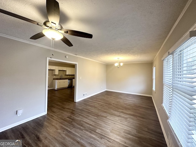 empty room featuring a textured ceiling, crown molding, and dark hardwood / wood-style floors