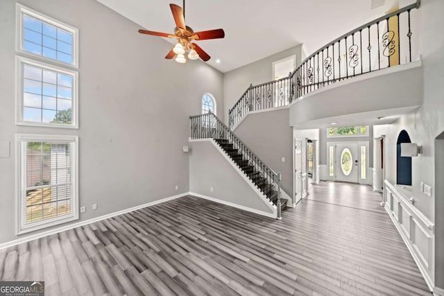 foyer featuring ceiling fan, hardwood / wood-style floors, and a high ceiling