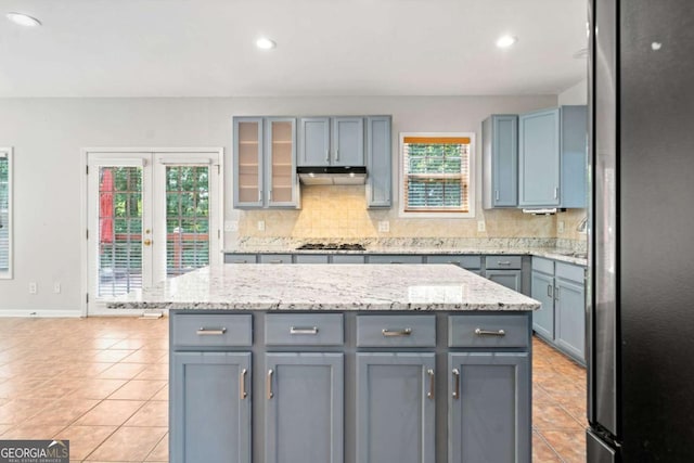 kitchen featuring a healthy amount of sunlight, a kitchen island, and tasteful backsplash