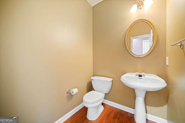 bathroom featuring hardwood / wood-style flooring and toilet