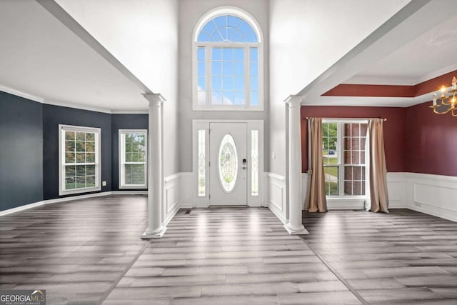 foyer entrance with crown molding, hardwood / wood-style floors, and a healthy amount of sunlight