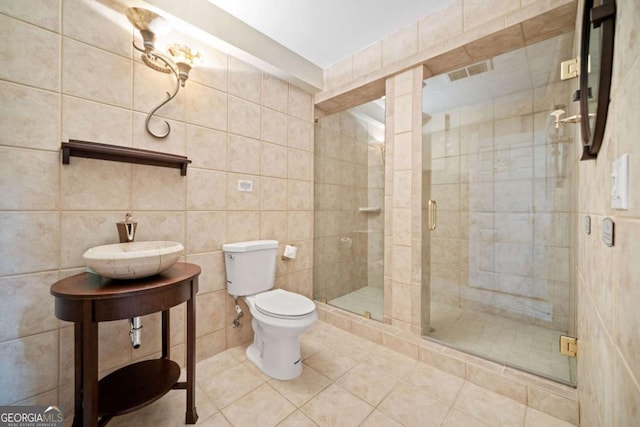 bathroom featuring walk in shower, toilet, and tile walls