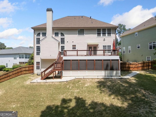 rear view of house with a lawn and a wooden deck