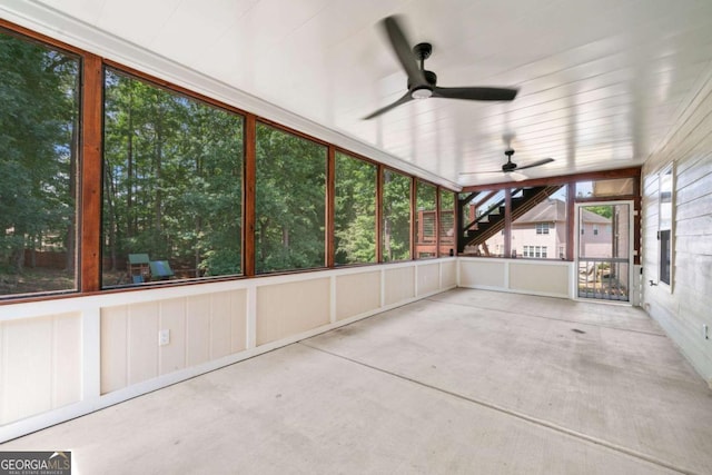 unfurnished sunroom featuring ceiling fan