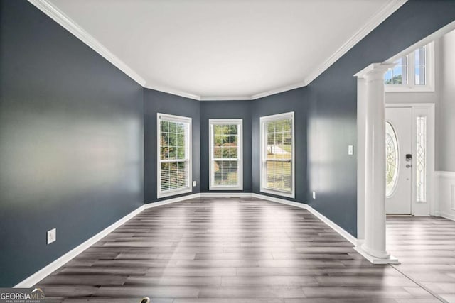 interior space featuring dark hardwood / wood-style flooring, crown molding, and decorative columns