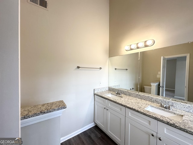 bathroom featuring wood-type flooring, vanity, and toilet