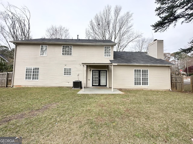 rear view of property featuring central air condition unit, a patio area, and a lawn