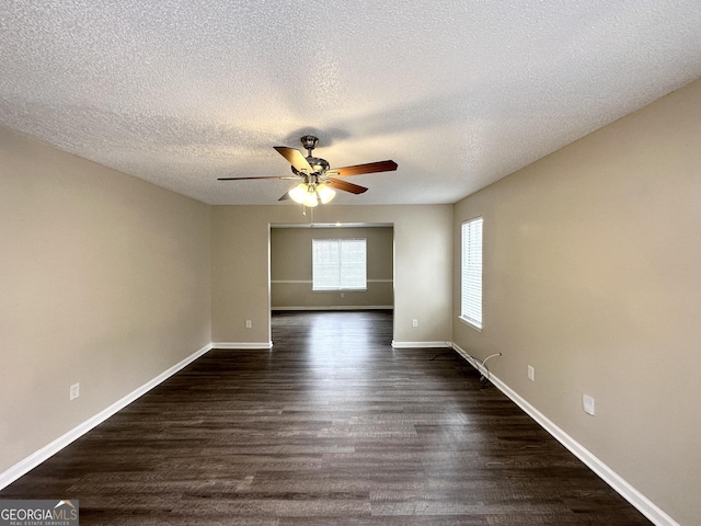 spare room featuring a textured ceiling, ceiling fan, and dark wood-type flooring