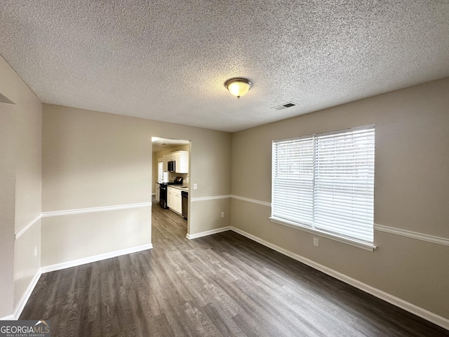 empty room with hardwood / wood-style flooring and a textured ceiling