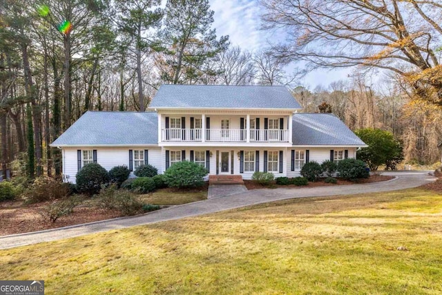 view of front of home featuring a balcony, a front lawn, and a porch