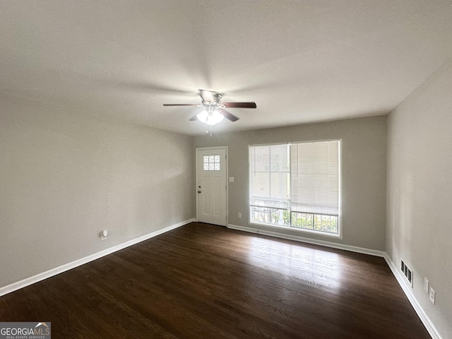 spare room with ceiling fan and dark wood-type flooring