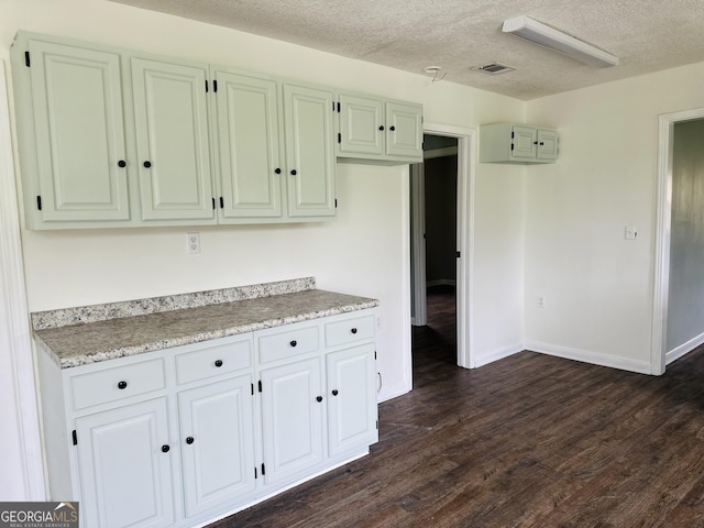 3039 Albany Ave, Waycross, GA 31503 - kitchen featuring dark wood-type flooring, a textured ceiling, and baseboards