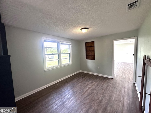 3039 Albany Ave, Waycross, GA 31503 - spare room featuring dark wood-style flooring, a textured ceiling, and baseboards