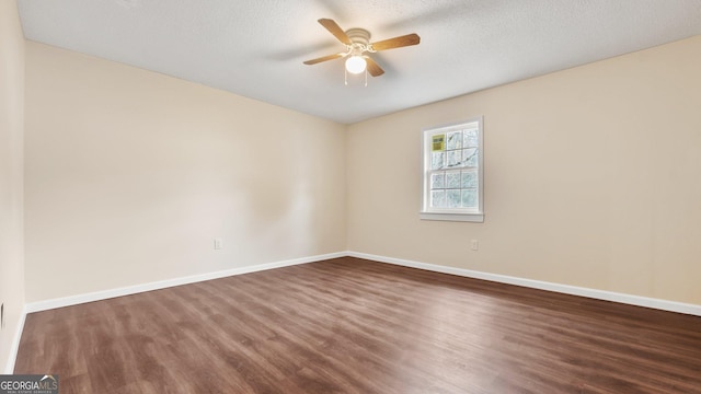 unfurnished room with ceiling fan, dark wood-type flooring, and a textured ceiling