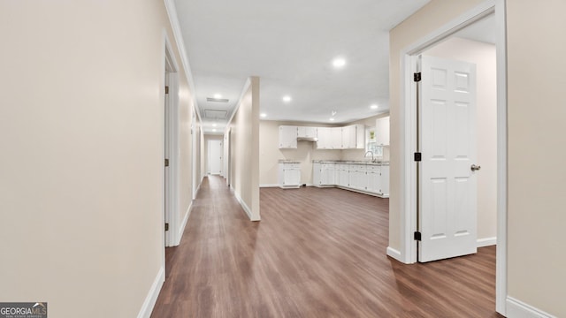 hallway with dark hardwood / wood-style flooring and sink