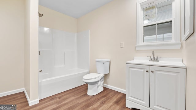 full bathroom with washtub / shower combination, wood-type flooring, vanity, and toilet