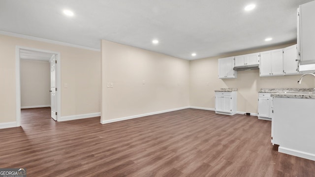 kitchen with white cabinetry, crown molding, and dark wood-type flooring