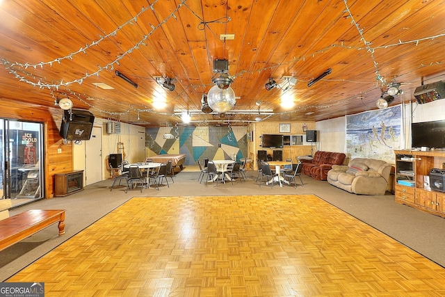 unfurnished living room with wooden walls, light parquet floors, and wooden ceiling