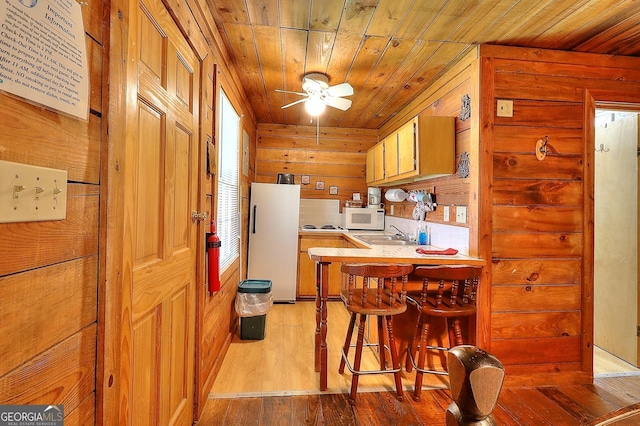 kitchen featuring decorative backsplash, light wood-type flooring, wood ceiling, white appliances, and wood walls