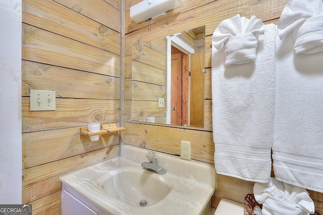 bathroom featuring wood walls and vanity