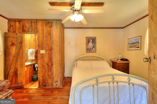 bedroom featuring hardwood / wood-style flooring, ceiling fan, and ornamental molding