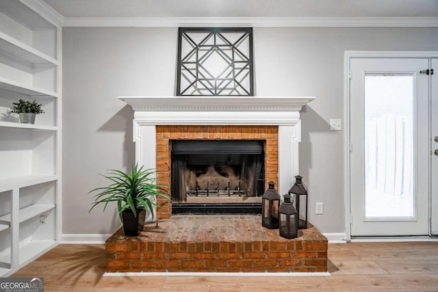 room details featuring built in features, crown molding, wood-type flooring, and a fireplace